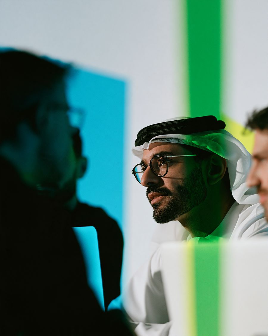 A consultant in a meeting, lit in green and blue
